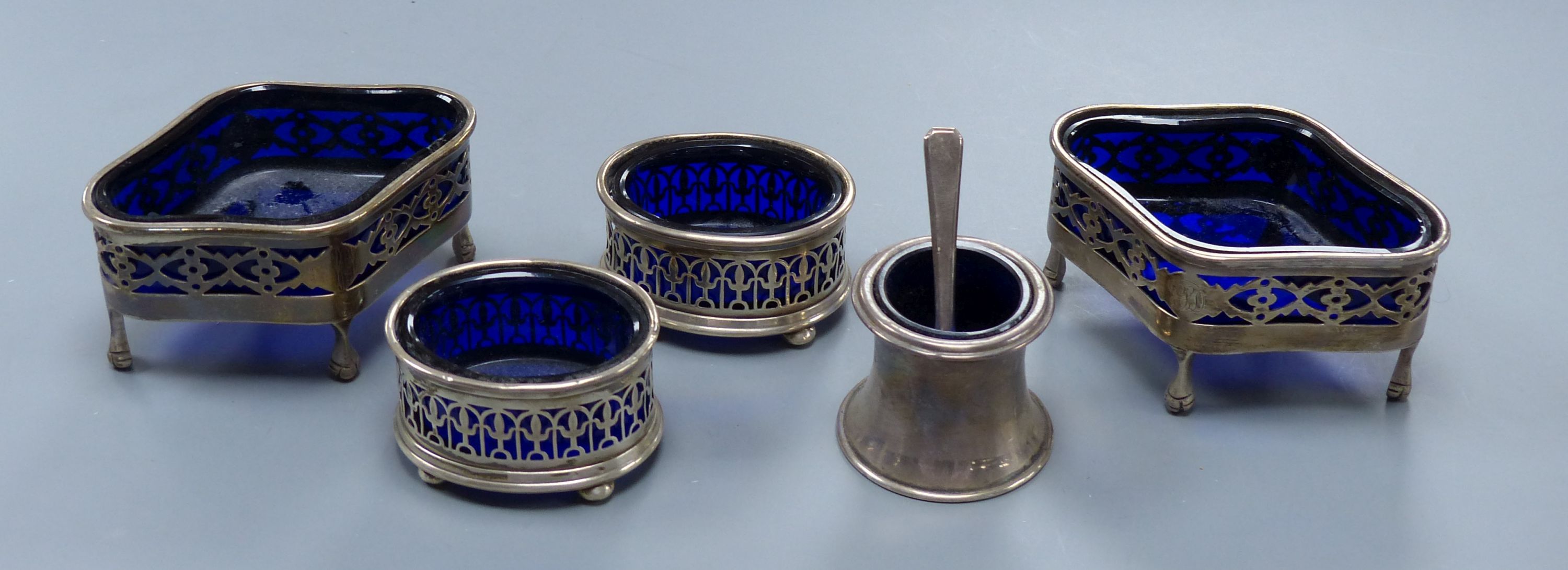A pair of Edwardian pierced silver quatrefoil shaped salts with blue glass liners, London, 190987mm and three other smaller silver salts.